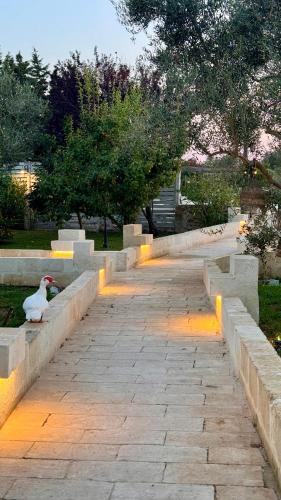 a bird sitting on a stone path in a park at Masseria Messapia Wine Resort & Spa Salento in Mesagne