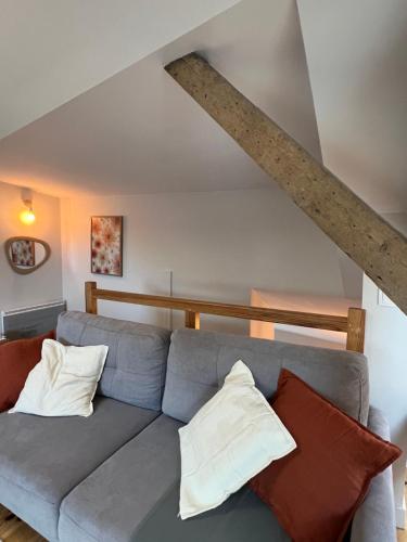 un salon avec un canapé bleu avec des oreillers dans l'établissement Appartement au cœur de Cauterets - vue montagne - Wifi, à Cauterets