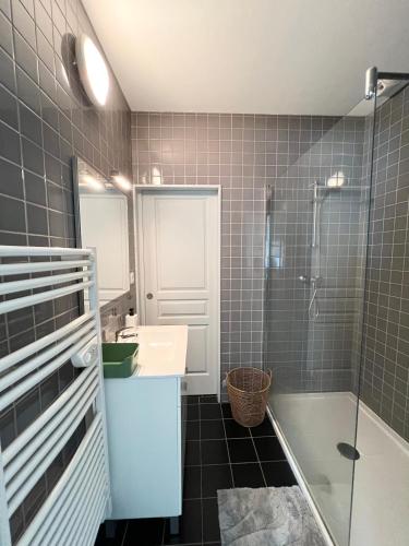 une salle de bain avec une douche, un lavabo et un miroir dans l'établissement Appartement au cœur de Cauterets - vue montagne - Wifi, à Cauterets