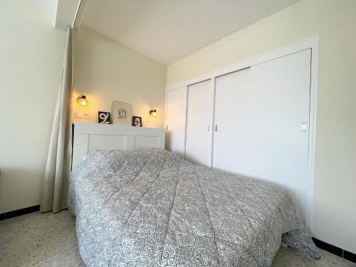 une chambre avec un lit et un grand placard dans l'établissement bel appartement proche plage, au Lavandou