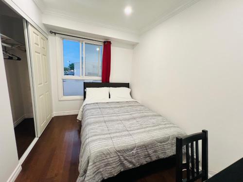 a small bedroom with a bed and a window at ComfyRoom in Toronto