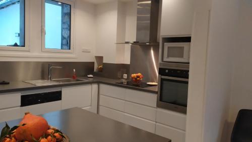 une cuisine avec une table avec un bol de fruits dessus dans l'établissement Gîte le Marmare, à Caussou