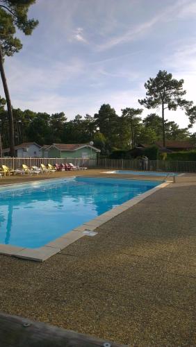 une piscine avec de l'eau bleue dans une cour dans l'établissement CHALET Soulac Sur MER, à Soulac-sur-Mer