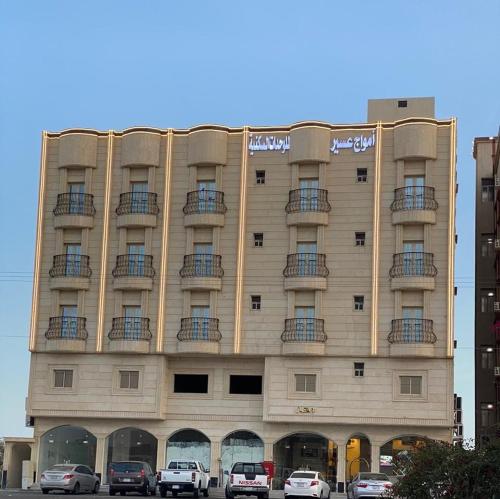 a large building with cars parked in front of it at امواج الشرق للشقق المخدومه in Khamis Mushayt