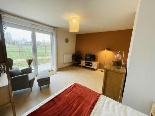Cet appartement comprend une chambre avec un lit et un salon avec une fenêtre. dans l'établissement 201 - Appartement T3 cosy, résidence calme, à Giberville
