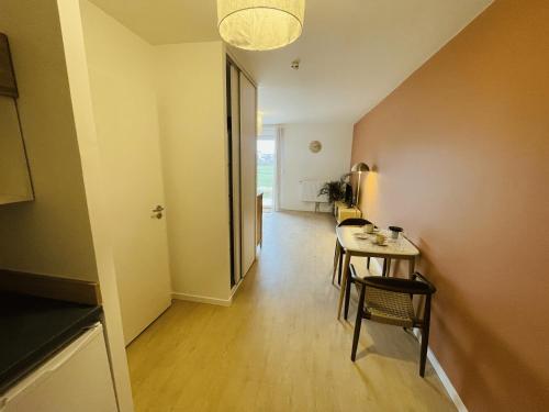 - un couloir avec une table et des chaises dans la chambre dans l'établissement 201 - Appartement T3 cosy, résidence calme, à Giberville