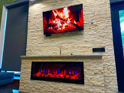 a fireplace with a tv on top of it at Qafqaz Retro Bungalow HOT POOL in Gabala