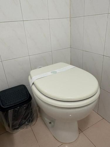 a white toilet in a bathroom with a trash can at station 27 in Perugia