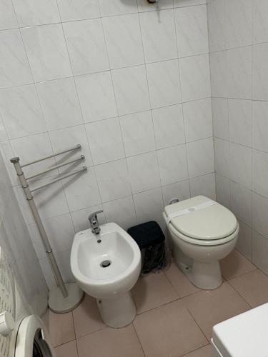 a white bathroom with a toilet and a bidet at station 27 in Perugia