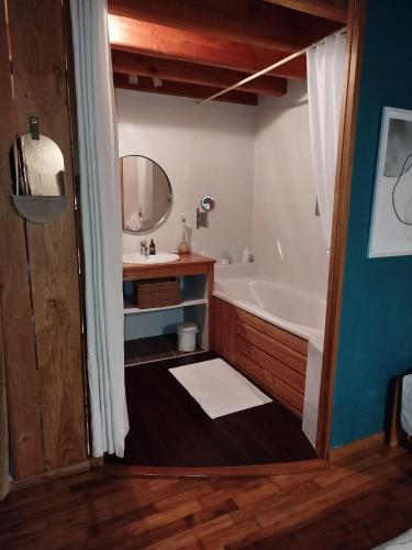 une salle de bain avec une baignoire, un lavabo et un miroir dans l'établissement Brindepaille, à Vallon-Pont-dʼArc
