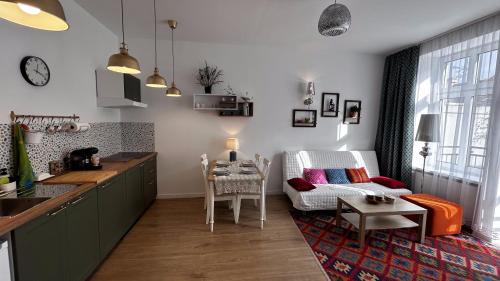 a kitchen and living room with a couch and a table at Przytulny apartament in Chorzów