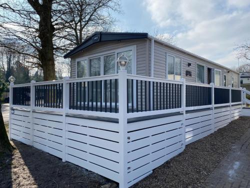 a tiny house with a white fence at Coghurst Hall Holiday Home Sleeps 6, 2 bedrooms in Hastings