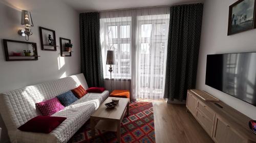 a living room with a couch and a television at Przytulny apartament in Chorzów