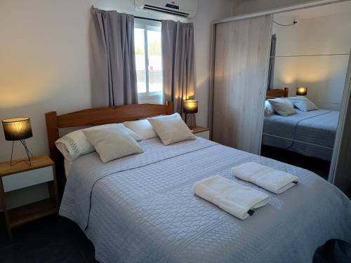 a bedroom with a bed with two towels on it at Departamento amplio en zona tranquila cercana al centro de Ezeiza in Ezeiza