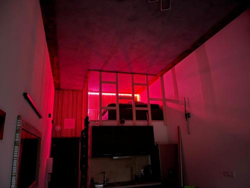 a room with pink lights and a bed in a room at Appart Massage Relax - Studio in Morbier