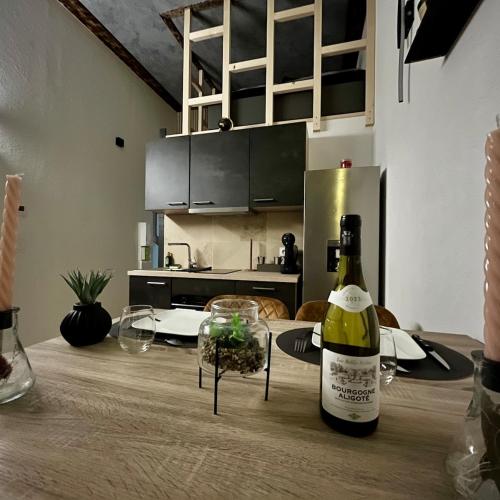 - une bouteille de vin assise sur une table dans la cuisine dans l'établissement Appart Massage Relax - Studio, à Morbier