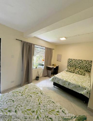 a bedroom with two beds and a window at Gaia in Medellín
