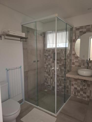 a bathroom with a shower with a toilet and a sink at Pontal Flats in Paraty