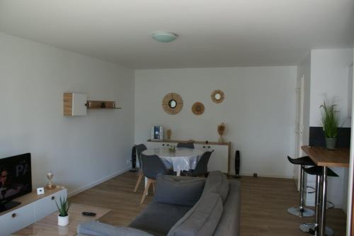 un salon avec un canapé et une table dans l'établissement VANNES Les JARDINS DU PORT, à Vannes