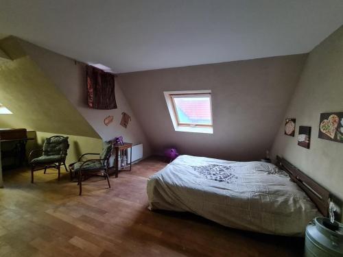 a bedroom with a bed and a window and a desk at Gîte La Ferme des Délices in Epfig