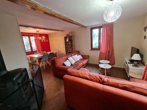 a living room with red couches and a table at Gîte La Ferme des Délices in Epfig