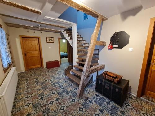a room with a wooden staircase in a house at Gîte La Ferme des Délices in Epfig