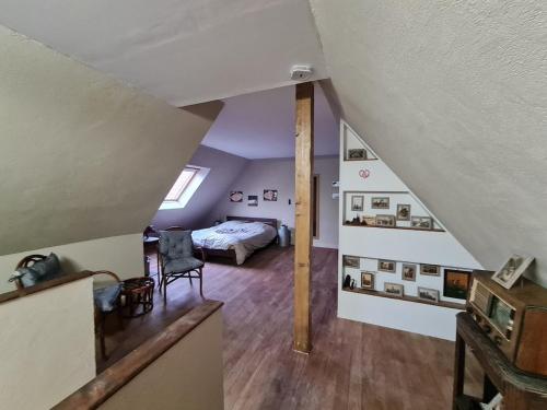 a attic room with a bed and a room with a staircase at Gîte La Ferme des Délices in Epfig