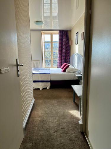 a small room with a bed and a window at Cit'Hotel le Challonge in Dinan