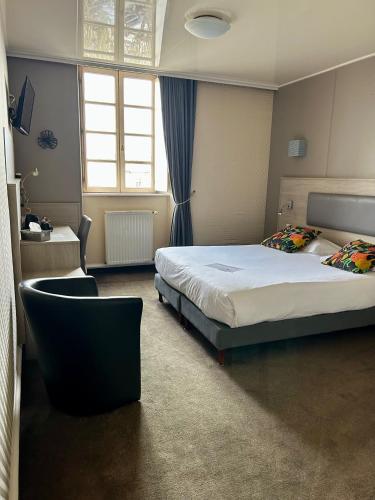a hotel room with a bed and a chair at Cit'Hotel le Challonge in Dinan