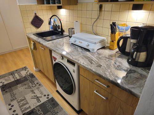 a kitchen counter with a washing machine and a sink at Studio Bohaterów Monte Cassino in Sopot