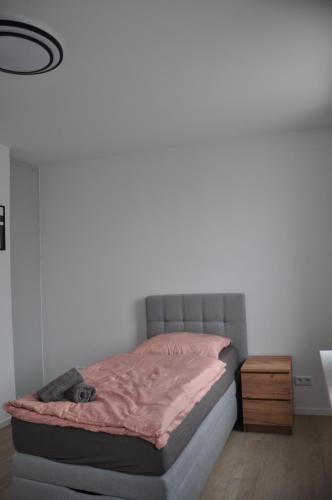 a bedroom with a bed with a pink comforter at Monteurwohnungen WalMel kostenloses Parken und W-LAN in Bütthard