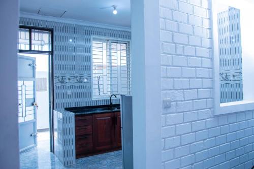 eine Küche mit Spüle und weißer Ziegelwand in der Unterkunft Entire home in Mlole, Kigoma, Tanzania in Gungu