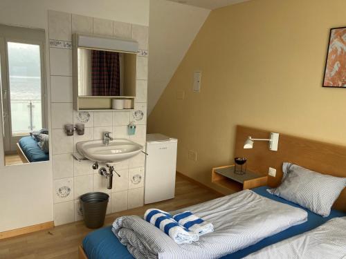 bagno con letto e lavandino in camera di Hotel Fähri Gersau a Gersau