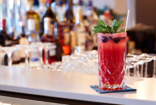 a drink sitting on a counter with a garnishment at Novotel Hamburg Central Station in Hamburg