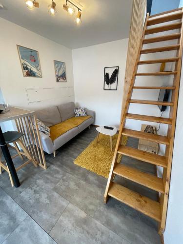 un salon avec un escalier et un canapé dans l'établissement Superbe studio à proximité du centre-ville, à Saint-Dié-des-Vosges