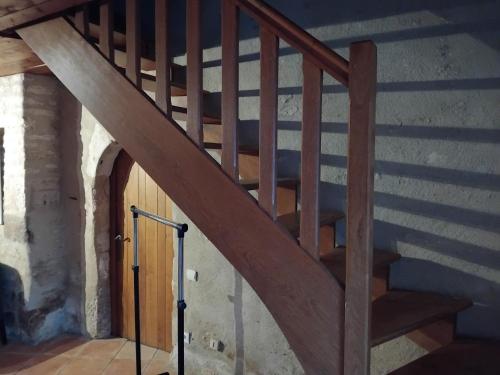 - un escalier en bois dans un bâtiment avec une porte en bois dans l'établissement Le Courcelot, à Saint-Loup-sur-Aujon