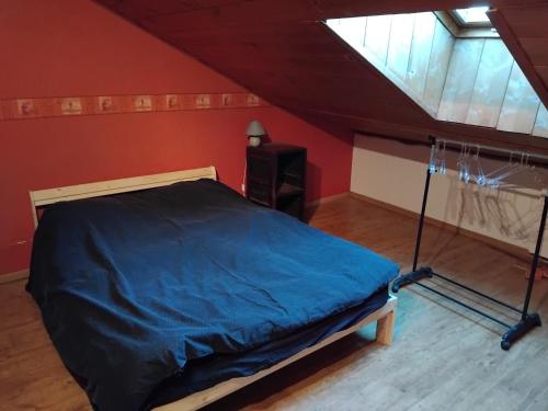 une chambre avec un lit avec une couette bleue dans l'établissement Le Courcelot, à Saint-Loup-sur-Aujon