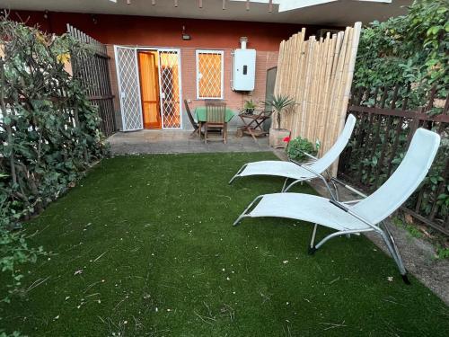 two chairs and a table in a yard at Mini Appartamento con giardino - Lovely studio for 2 with garden in La Giustiniana