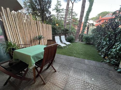 a patio with a table and chairs and a fence at Mini Appartamento con giardino - Lovely studio for 2 with garden in La Giustiniana