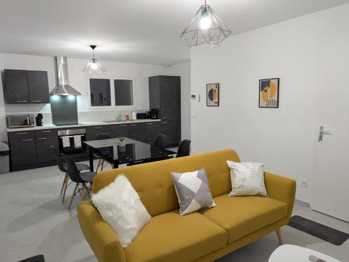 a living room with a yellow couch and a kitchen at Une Villa En Montagne in Marnaz