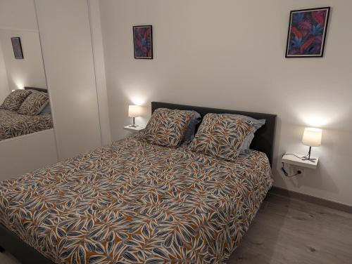 a bedroom with a bed with two lamps on the wall at Une Villa En Montagne in Marnaz