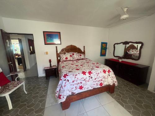 a bedroom with a bed and a chair and a mirror at Villa Antonia 16 in Sosúa