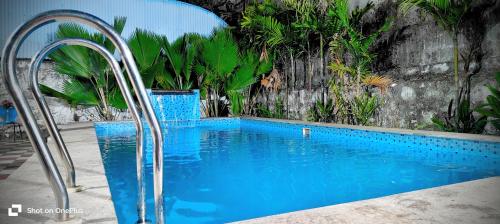 a swimming pool with blue water in a yard at Ocean Pearl Beach Villa & Retreat in Mahabalipuram