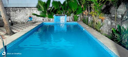 a blue swimming pool with a water fountain at Ocean Pearl Beach Villa & Retreat in Mahabalipuram