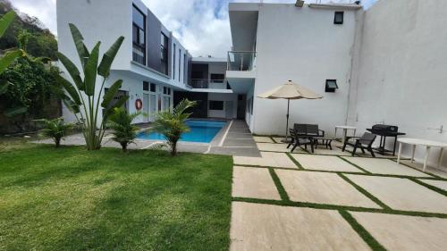 a backyard with a pool and a table and chairs at Hotel Boutique Manta in Los Ayala