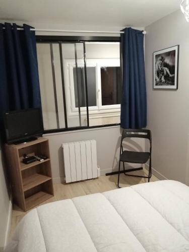 une chambre avec un lit, une fenêtre et une chaise dans l'établissement Clameli, à Gien