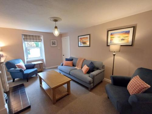 a living room with couches and chairs and a table at Creel Cottage Seatown Cullen with Garden in Cullen