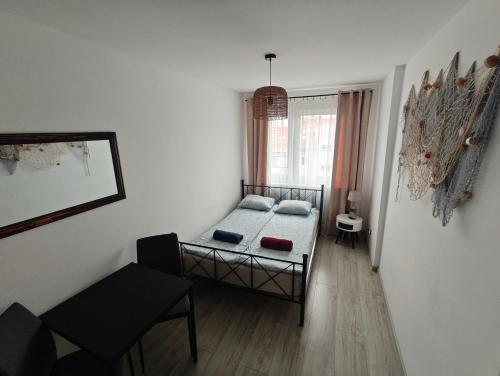 a small bedroom with a bed and a window at Kraken Apart in Kołobrzeg