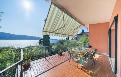 a balcony with a table and chairs and a view of the water at Casa Ileana in Gargnano