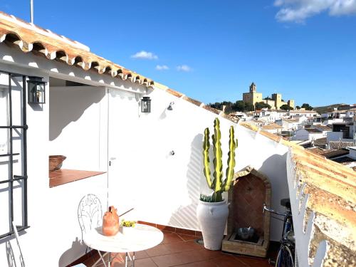 a white house with a balcony with a table and cactus at Casa Torre Hacho in Antequera
